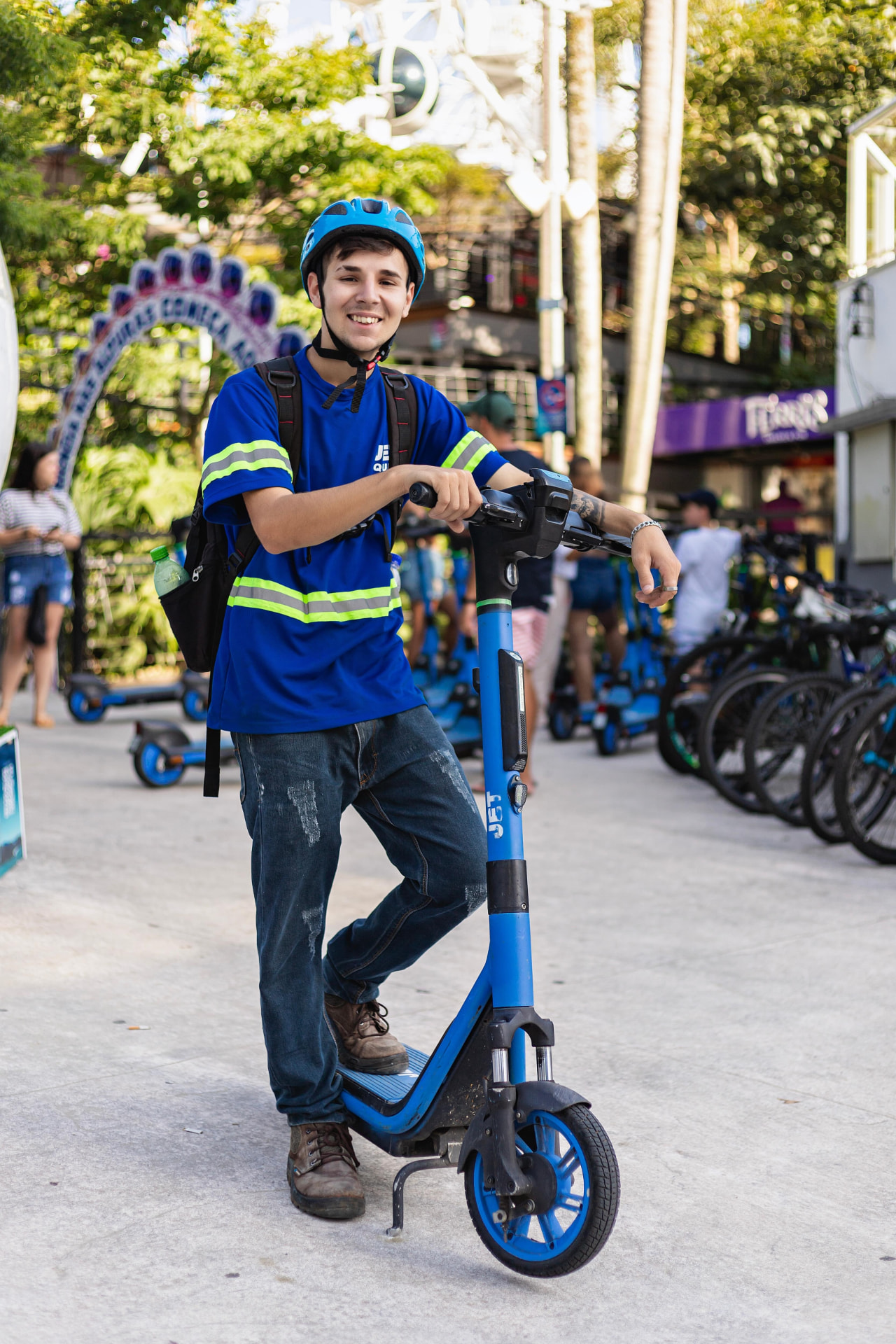 Estudante com capacete apoiado em um patinete elétrico JET